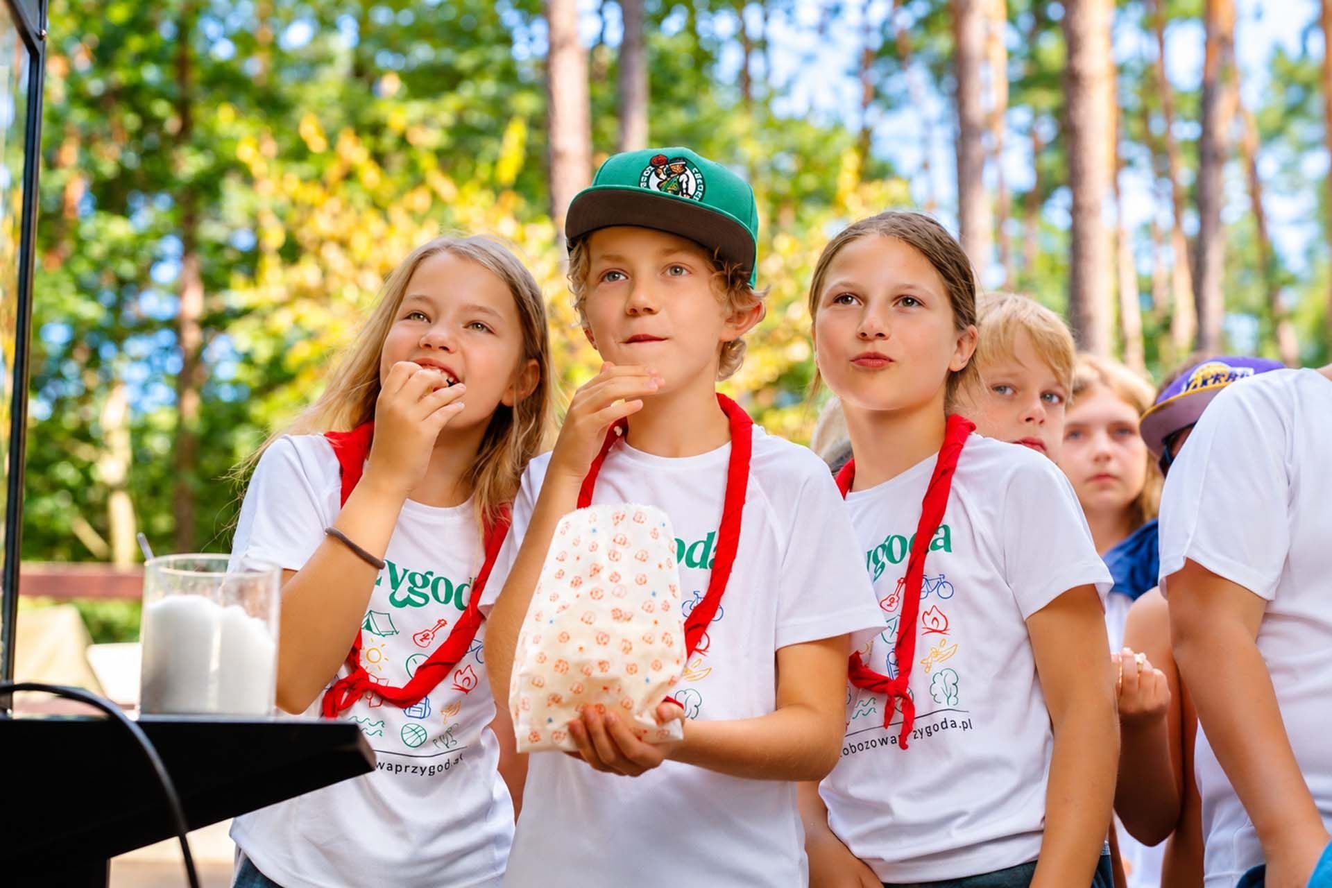 Dzieci jedzą popcorn na obozie w Smerzynie