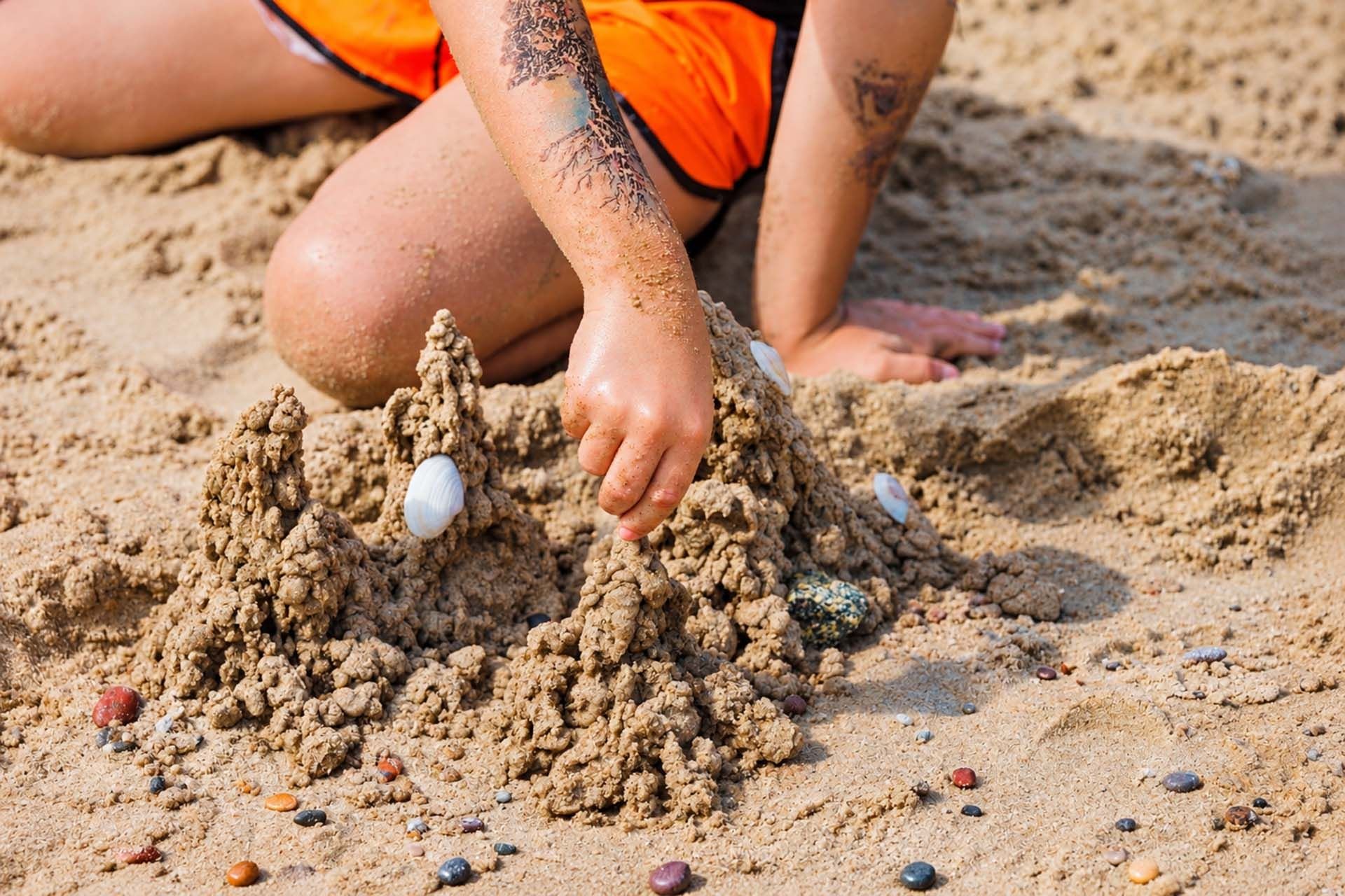 Budowanie zamku z piasku na plaży w Pogorzelicy