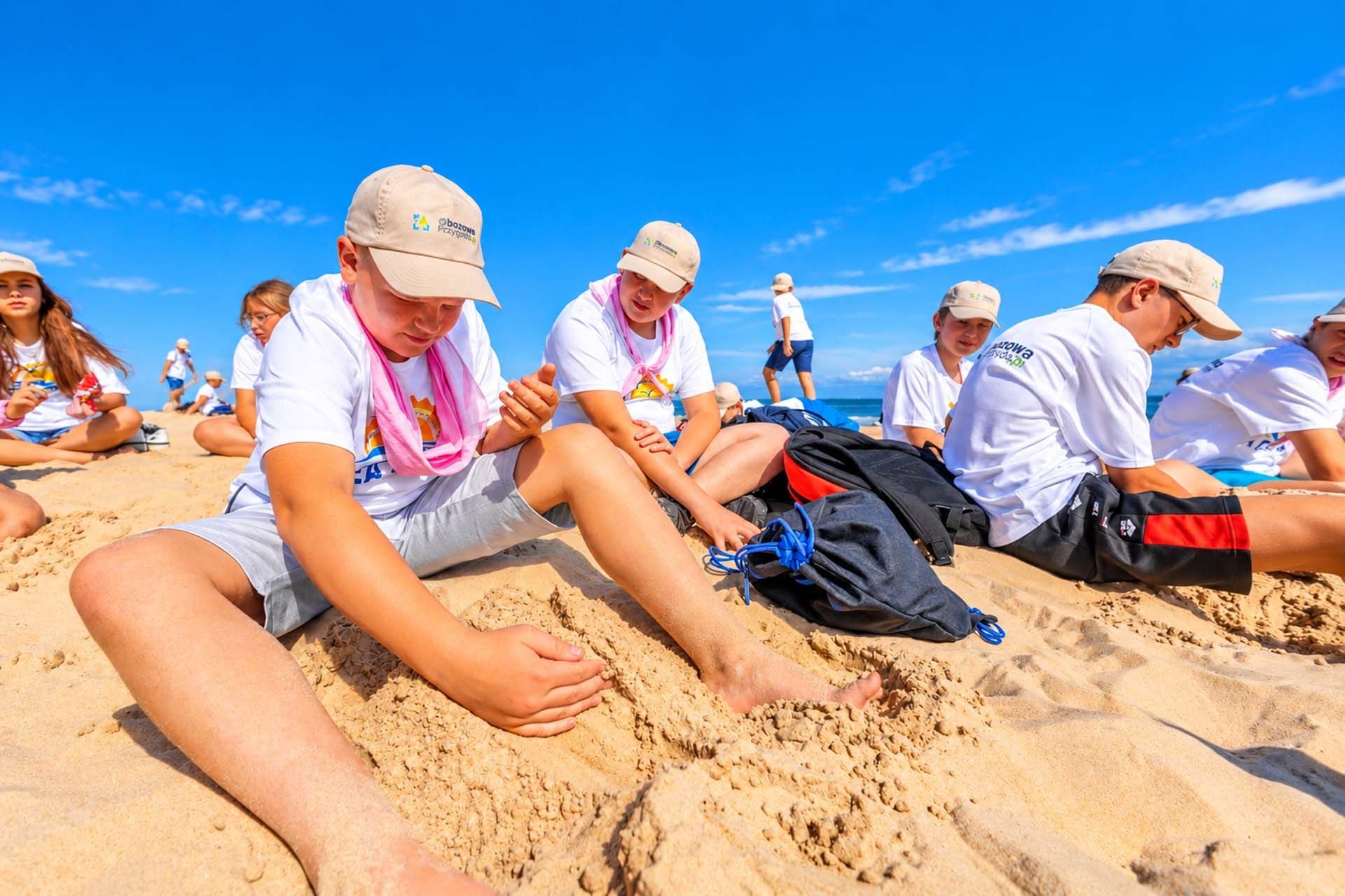 Chłopiec bawi się w piasku na plaży w Łebie