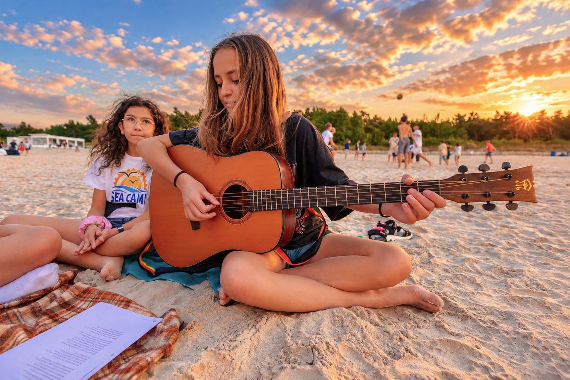Dzieci grają na gitarze na plaży w Łebie