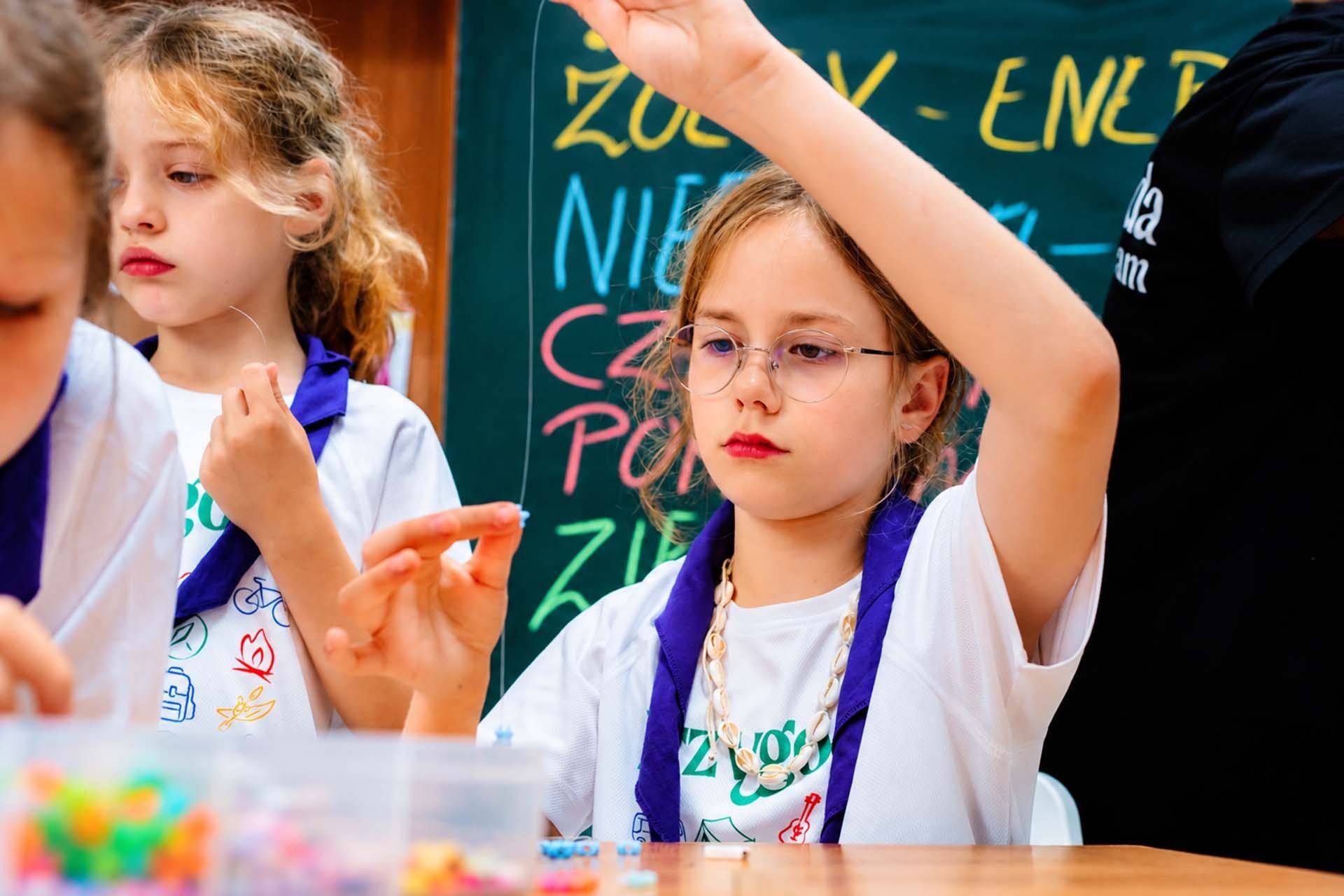 Dziewczynki robią bransoletki z koralików na Kids Camp w Smerzynie