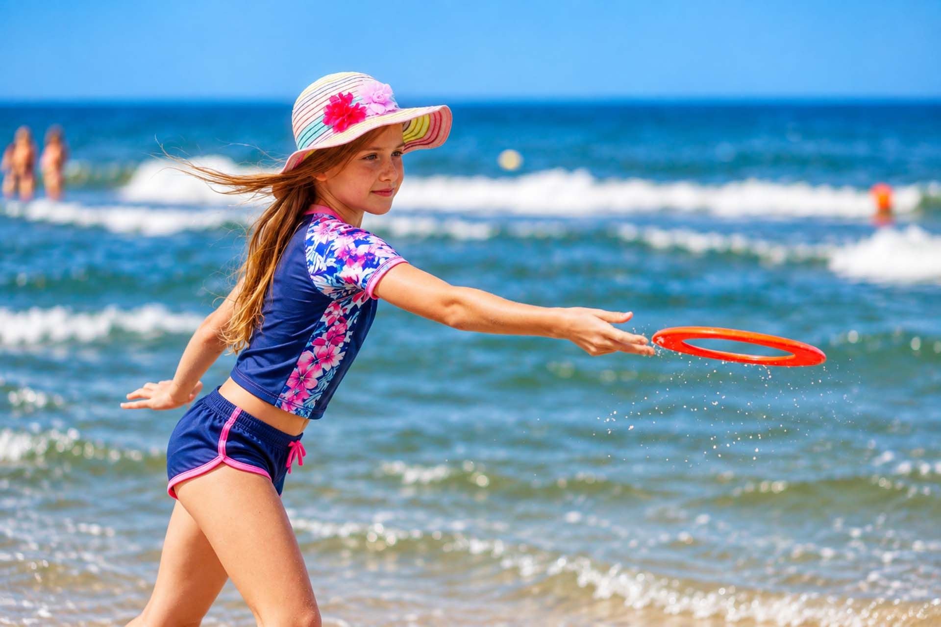 Dziewczynka rzuca frisbee nad morzem w Pogorzelicy