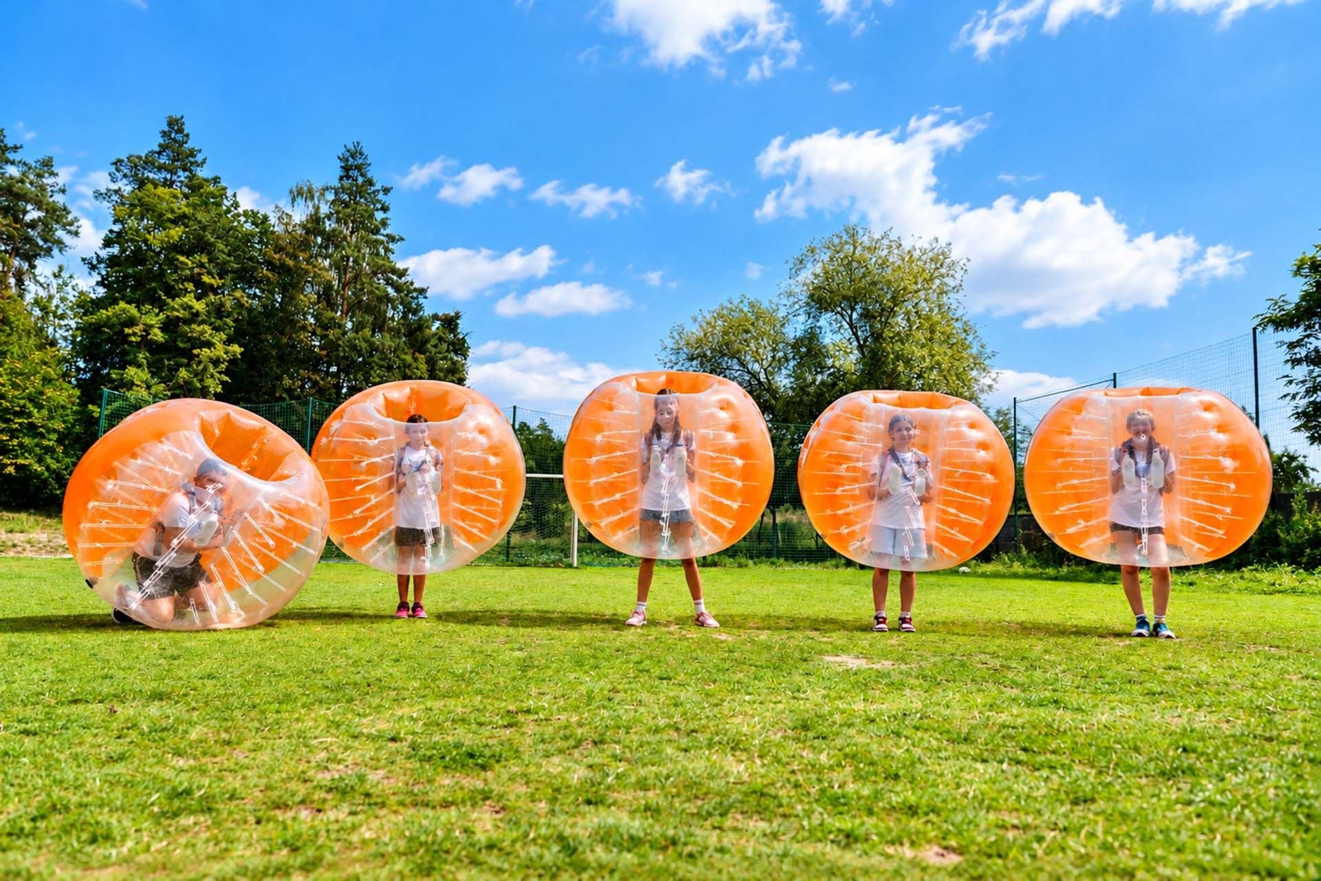 Dziewczynki grają w bumper ball na boisku w Smerzynie