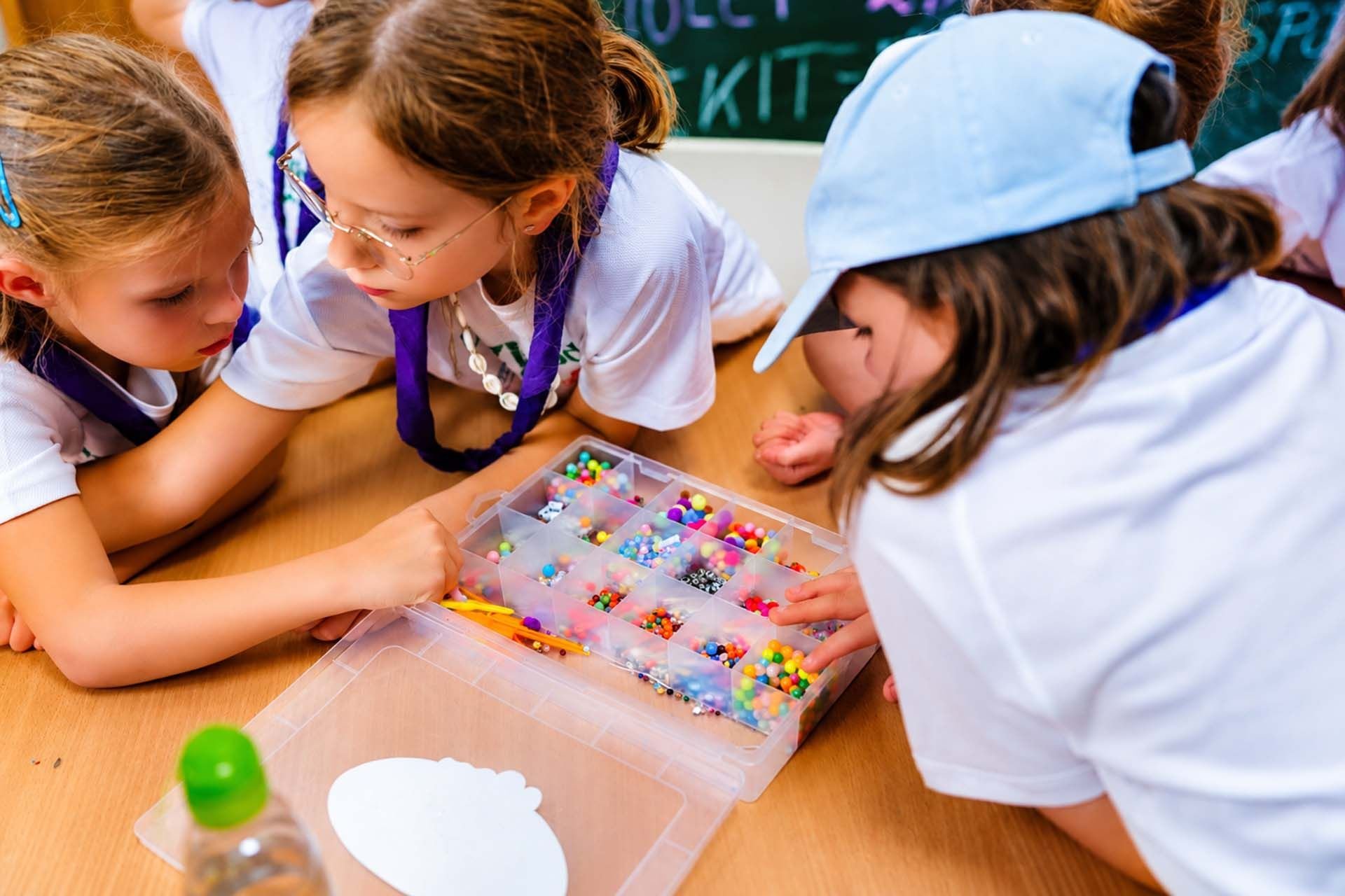 Dziewczynki podczas kids camp robią bransoletki z koraliczków