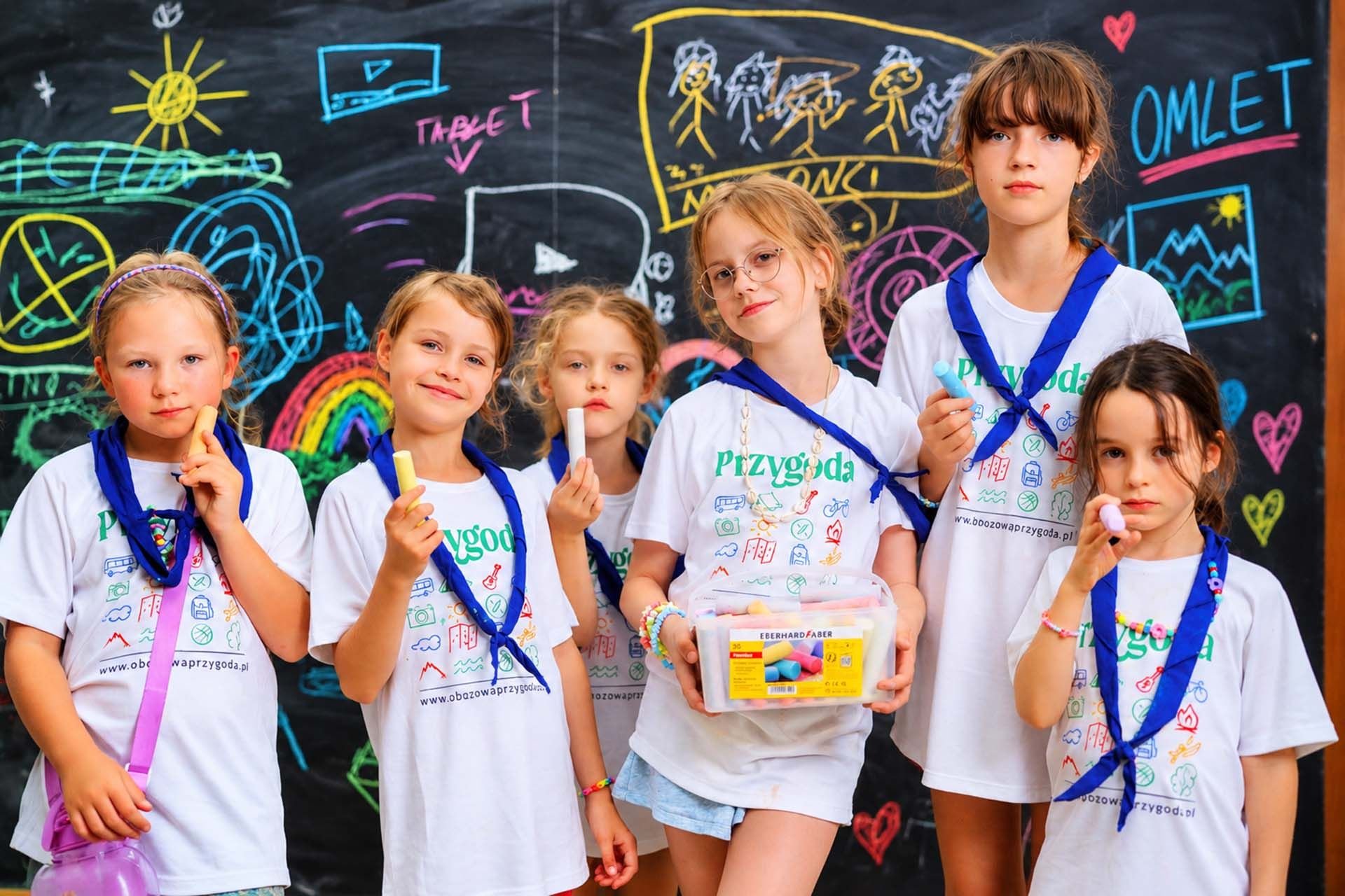 Dziewczynki z kredą przed tablicą Kids Camp w Smerzynie