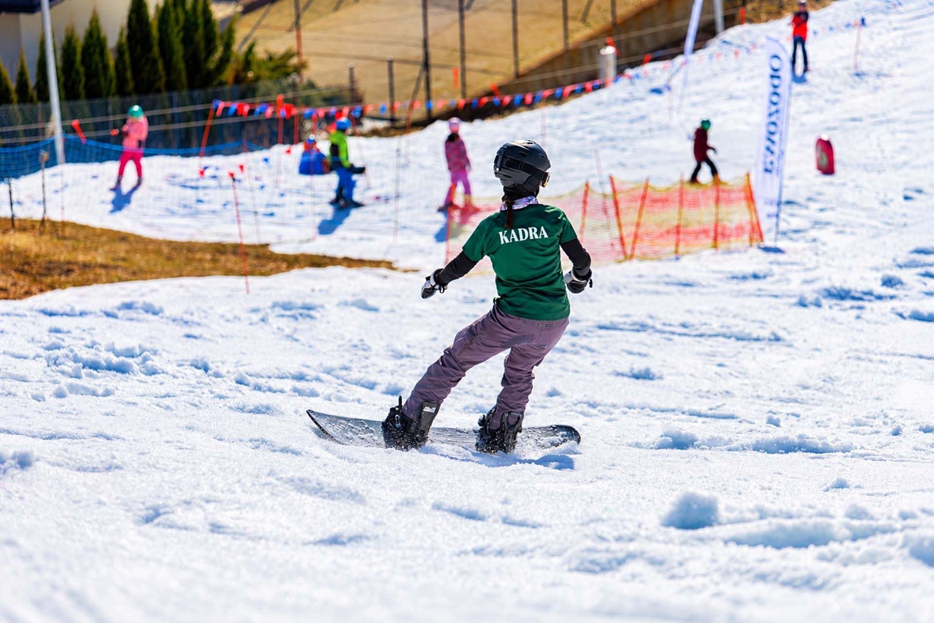 Kadra zjeżdża na snowboardzie - bezpieczne snowboardowanie na obozie
