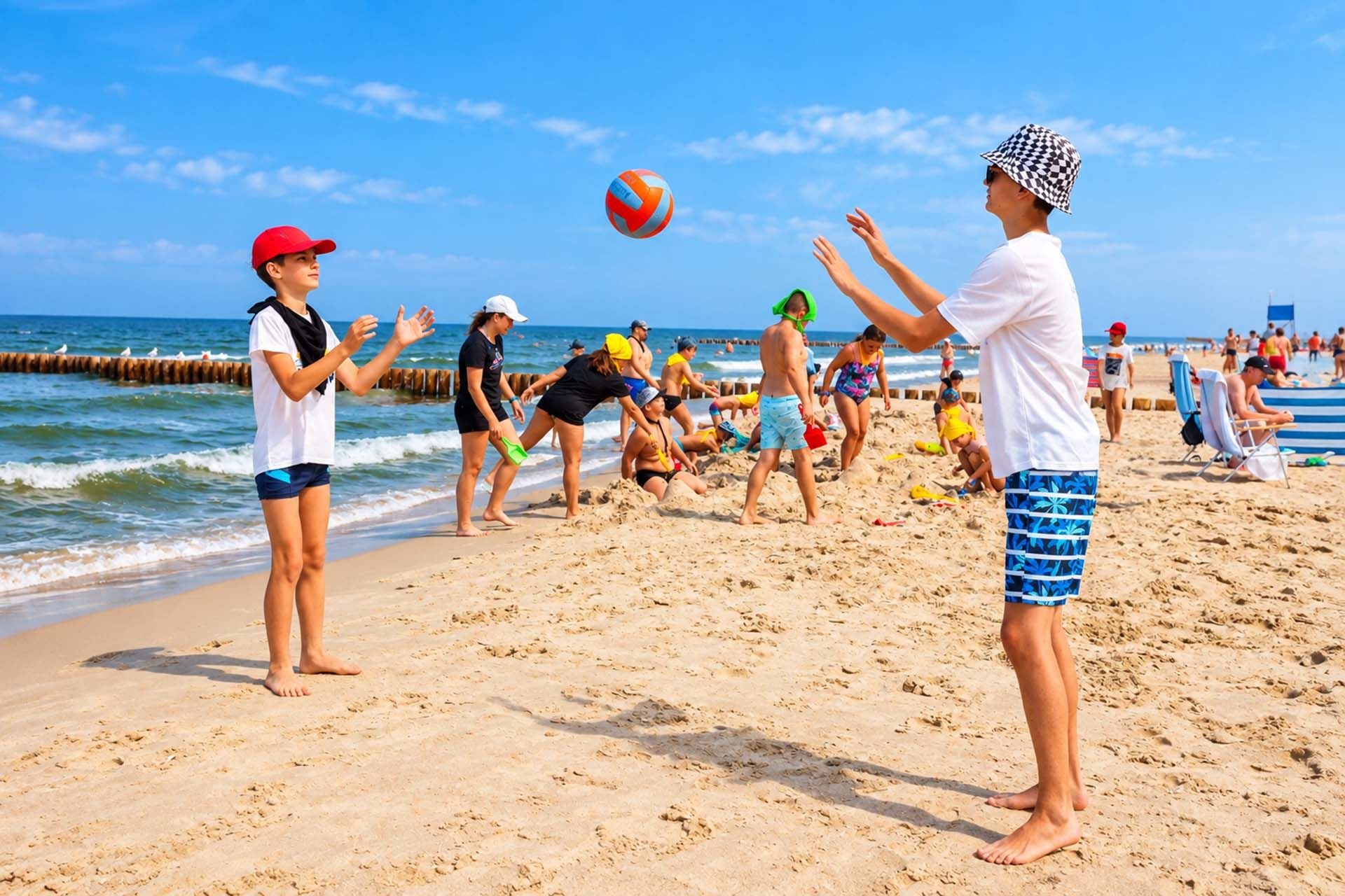 Chłopcy grają w piłkę na plaży nad morzem