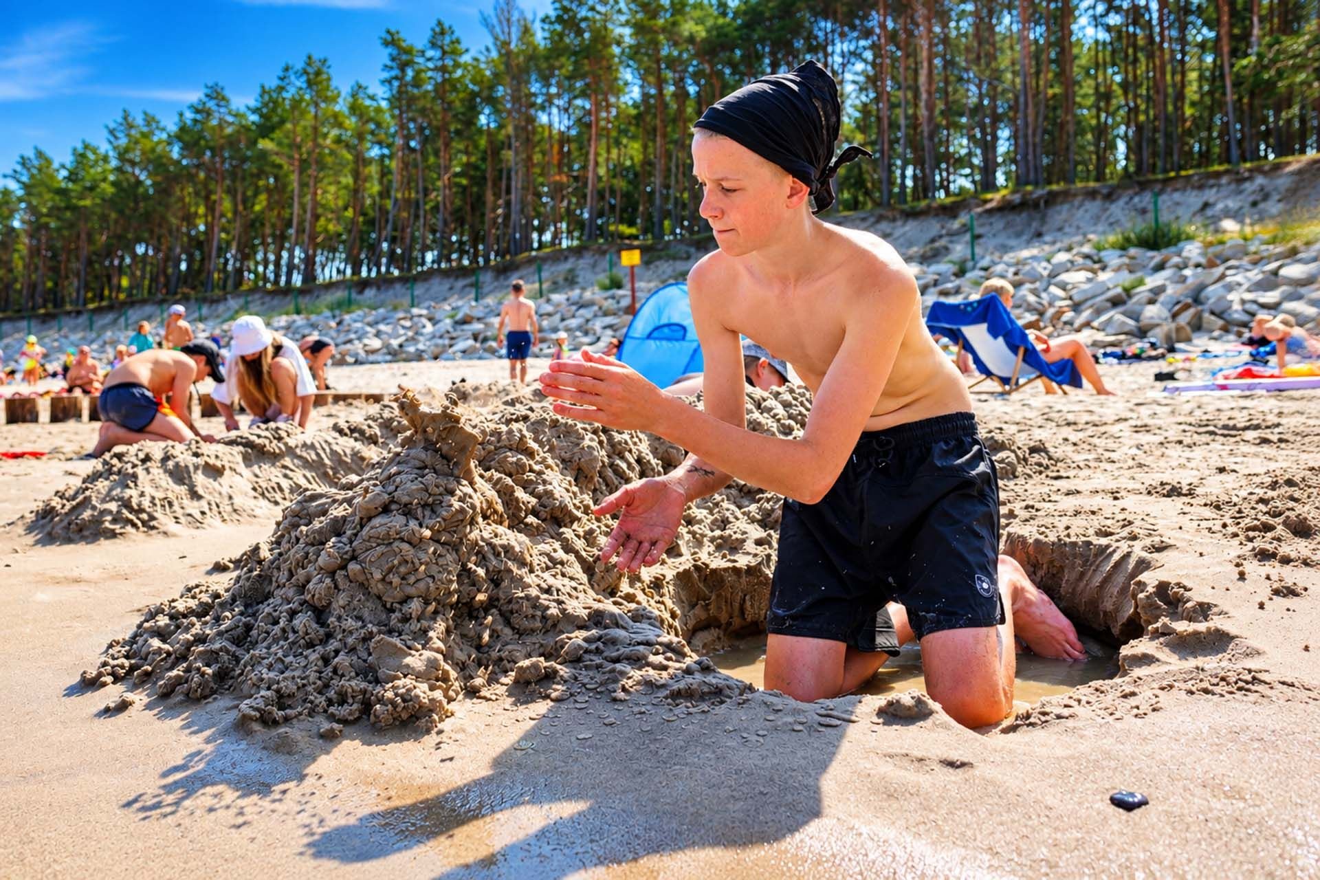 Nastolatek buduje zamek z piasku podczas Sea Camp w Pogorzelicy