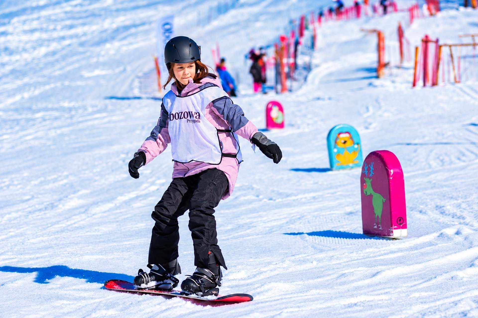 dziewczynka zjeżdża na obozie snowboardowym w Zakopanem