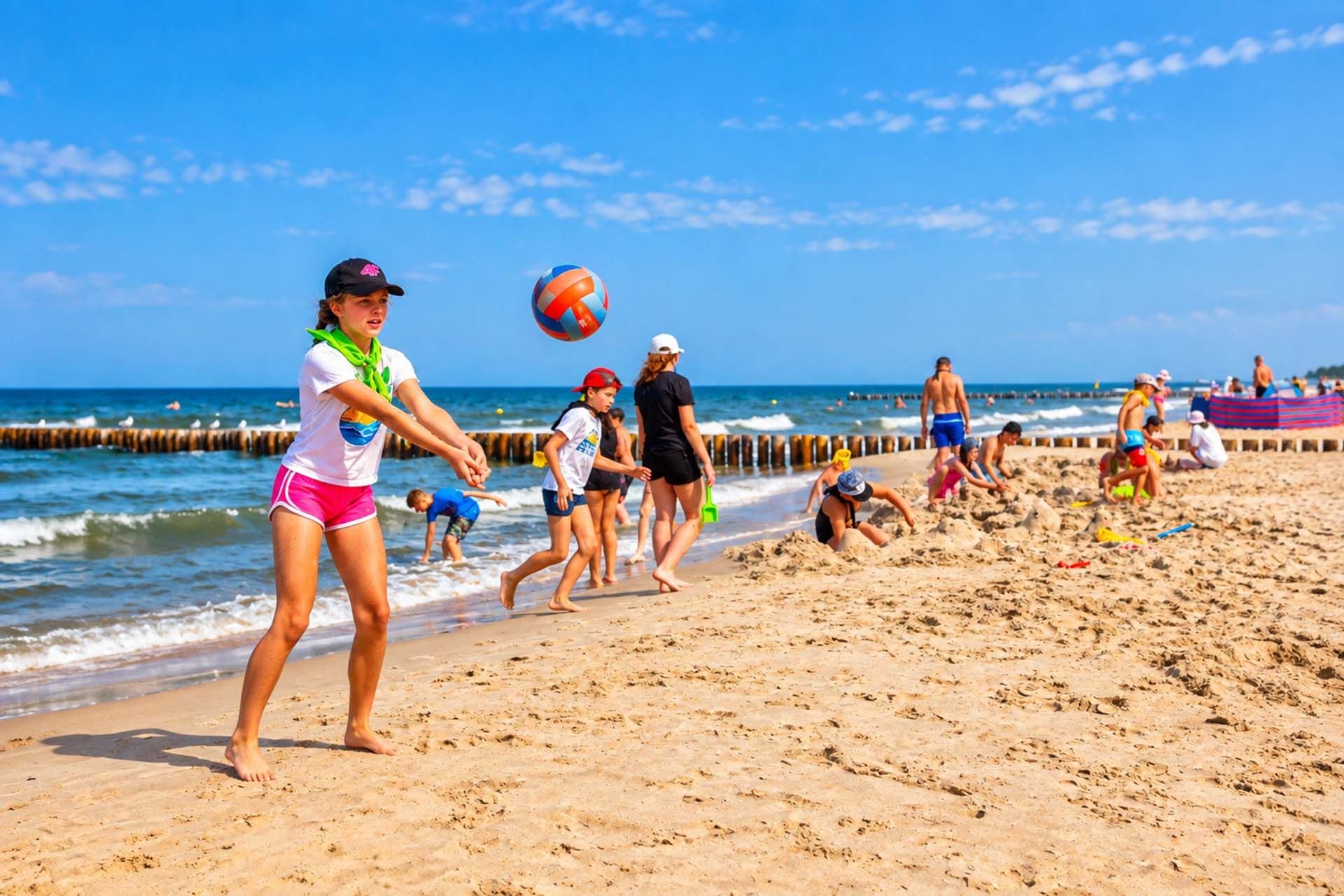 Dziewczynka odbija piłkę podczas siatkówki plażowej nad Bałtykiem