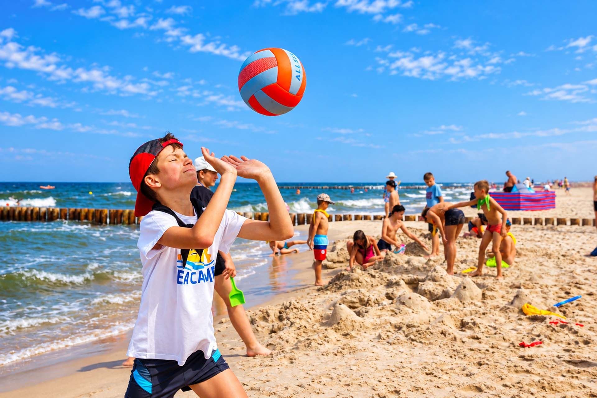 Chłopiec odbija piłkę podczas siatkówki na plaży