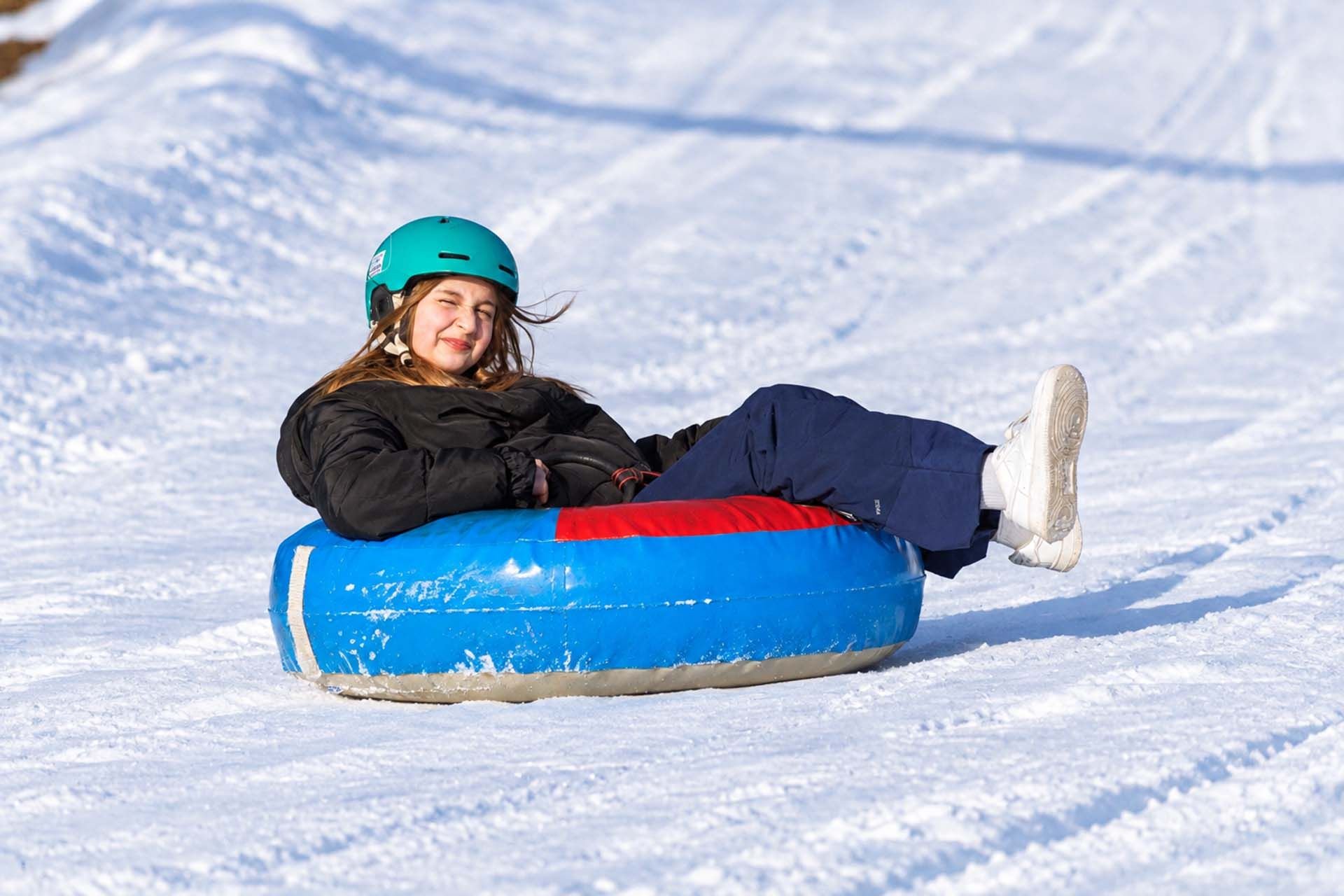 Dziewczynka zjeżdża na snowtubingu podczas zimowiska