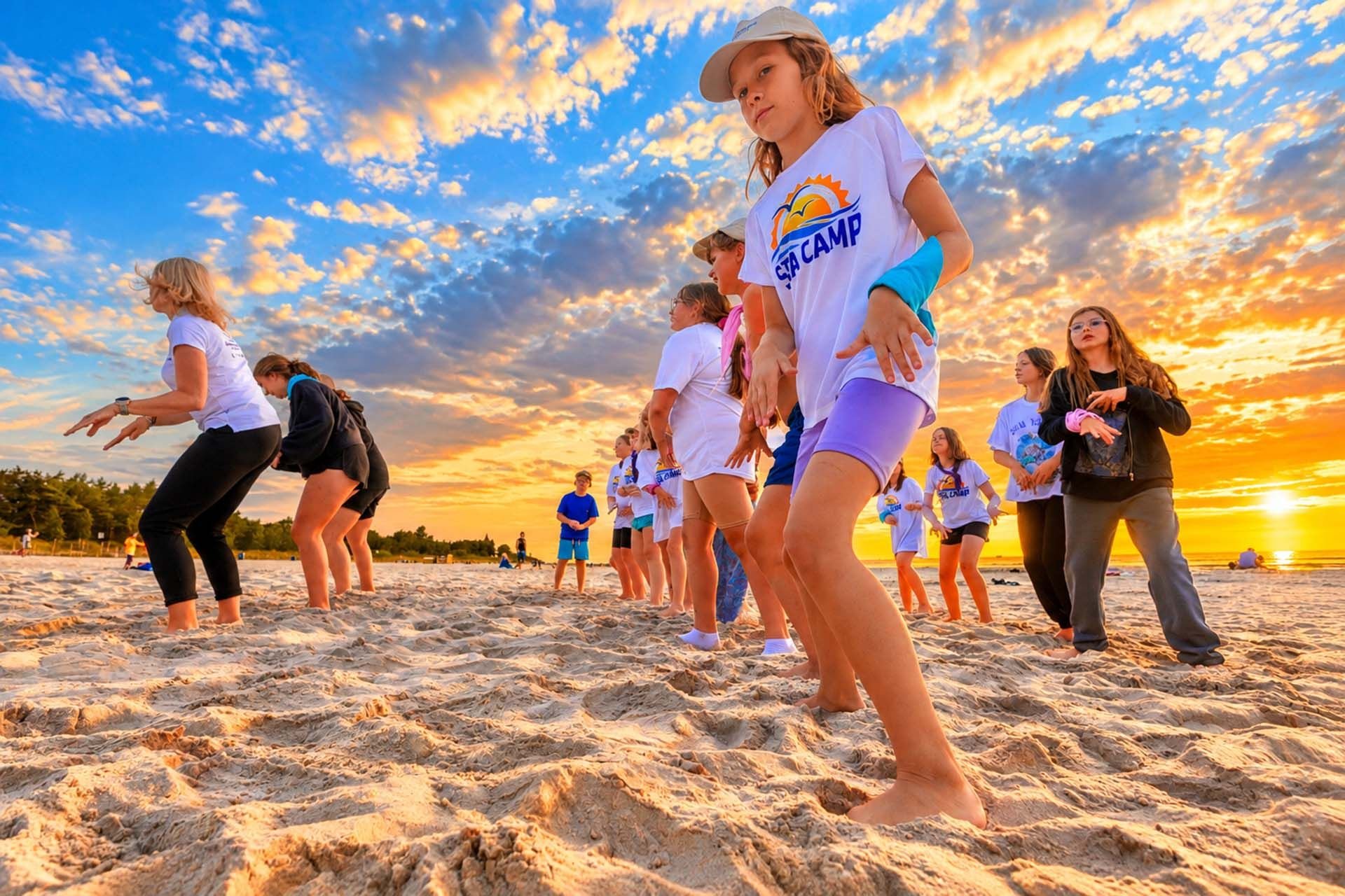 Taniec uczestników Sea Camp na plaży o zachodzie słońca