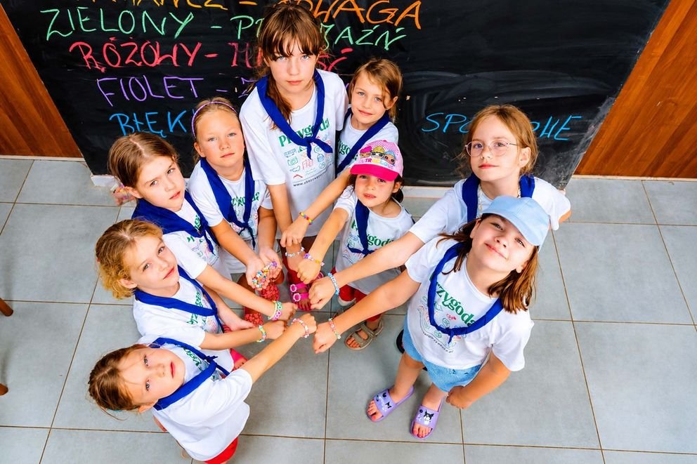 Dziewczynki pokazują swoje koraliczki w grupie zdjęcie z góry na kids camp