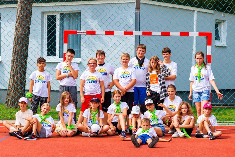 Grupowe zdjęcie obozu Sea Camp na boisku piłkarskim