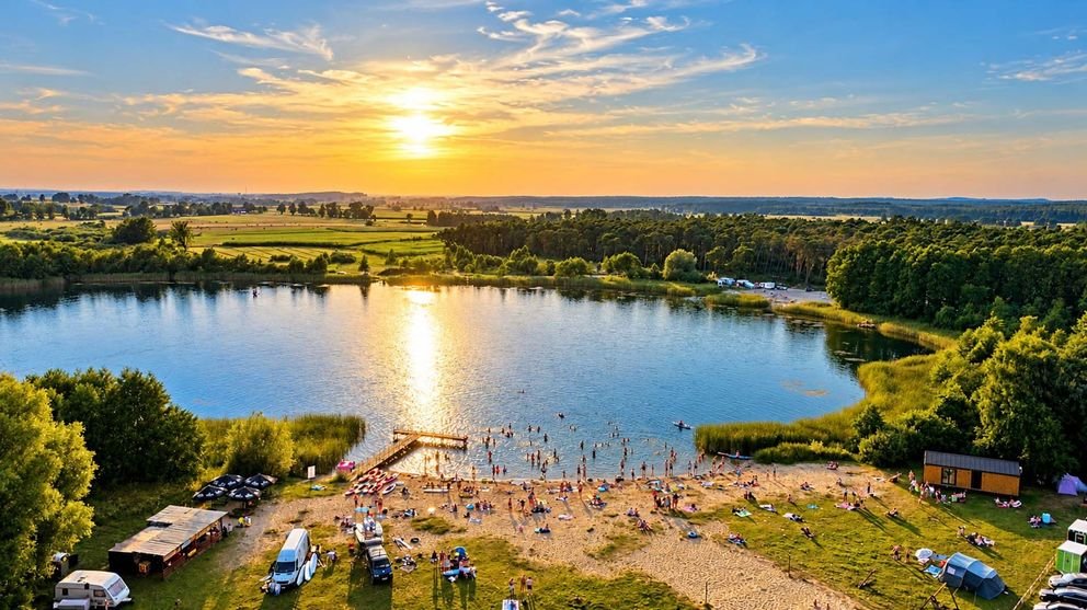 Plaża w Smerzynie, dzieci i młodzież nad jeziorem o zachodzie słońca