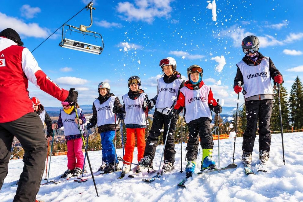 Dzieci na obozie Ski Camp słuchają instruktora i czekają na zjazd