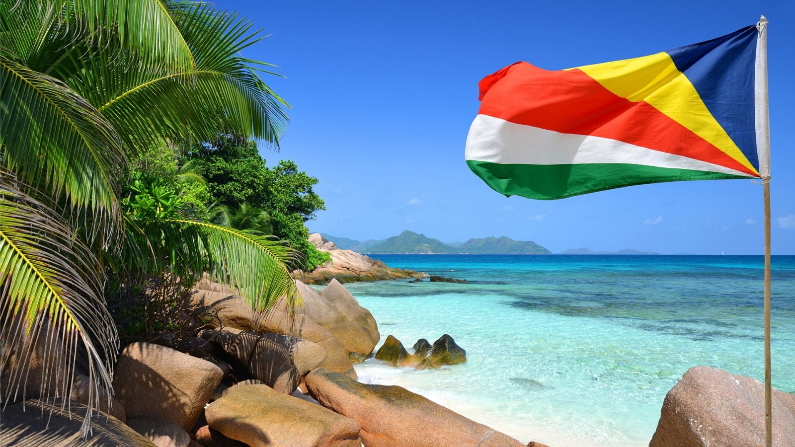 Plaża Anse Severe z flagą Seszeli na wyspie La Digue na Oceanie Indyjskim.