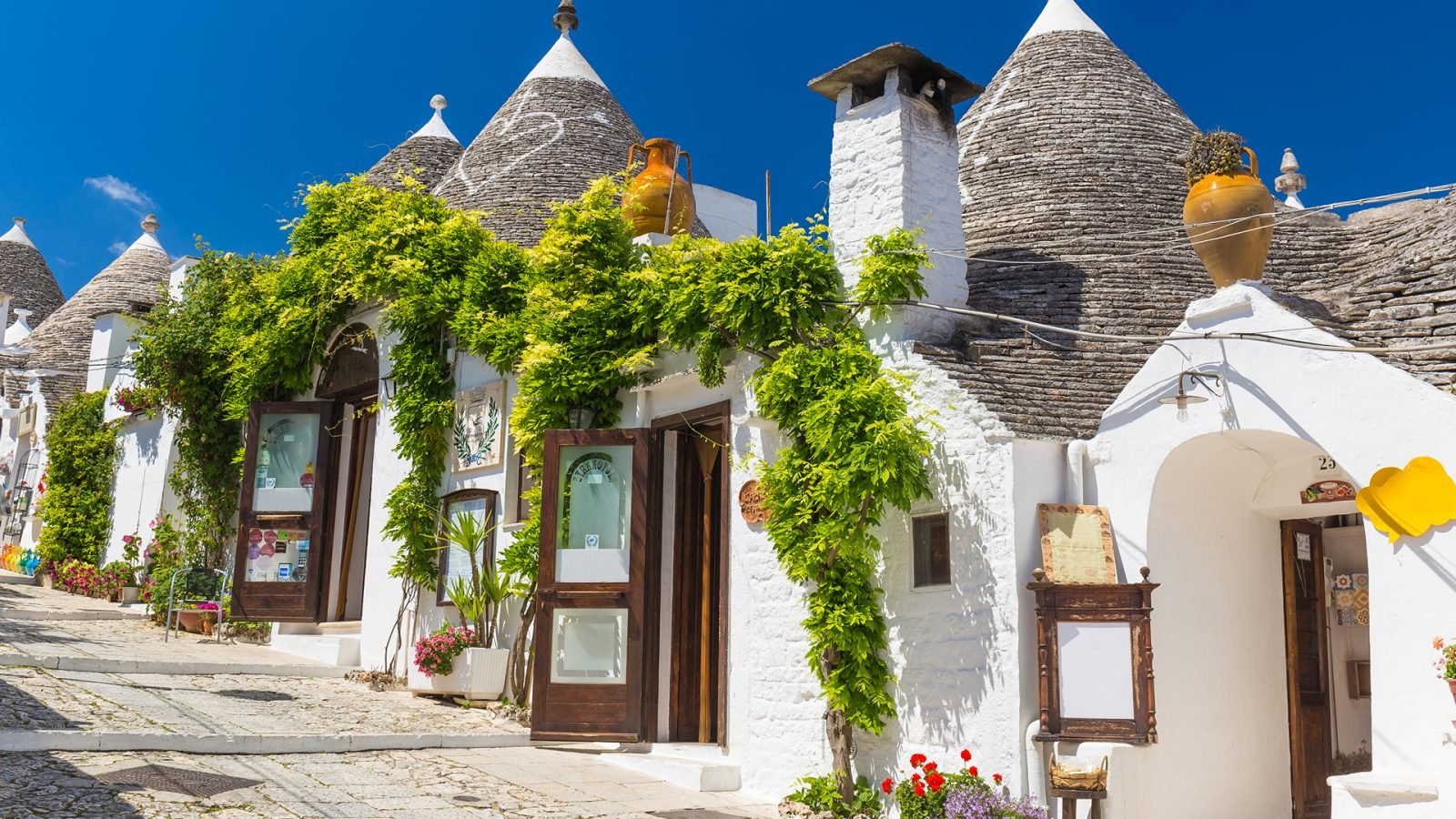 Domki Trulli porośnięte zielonym bluszczem