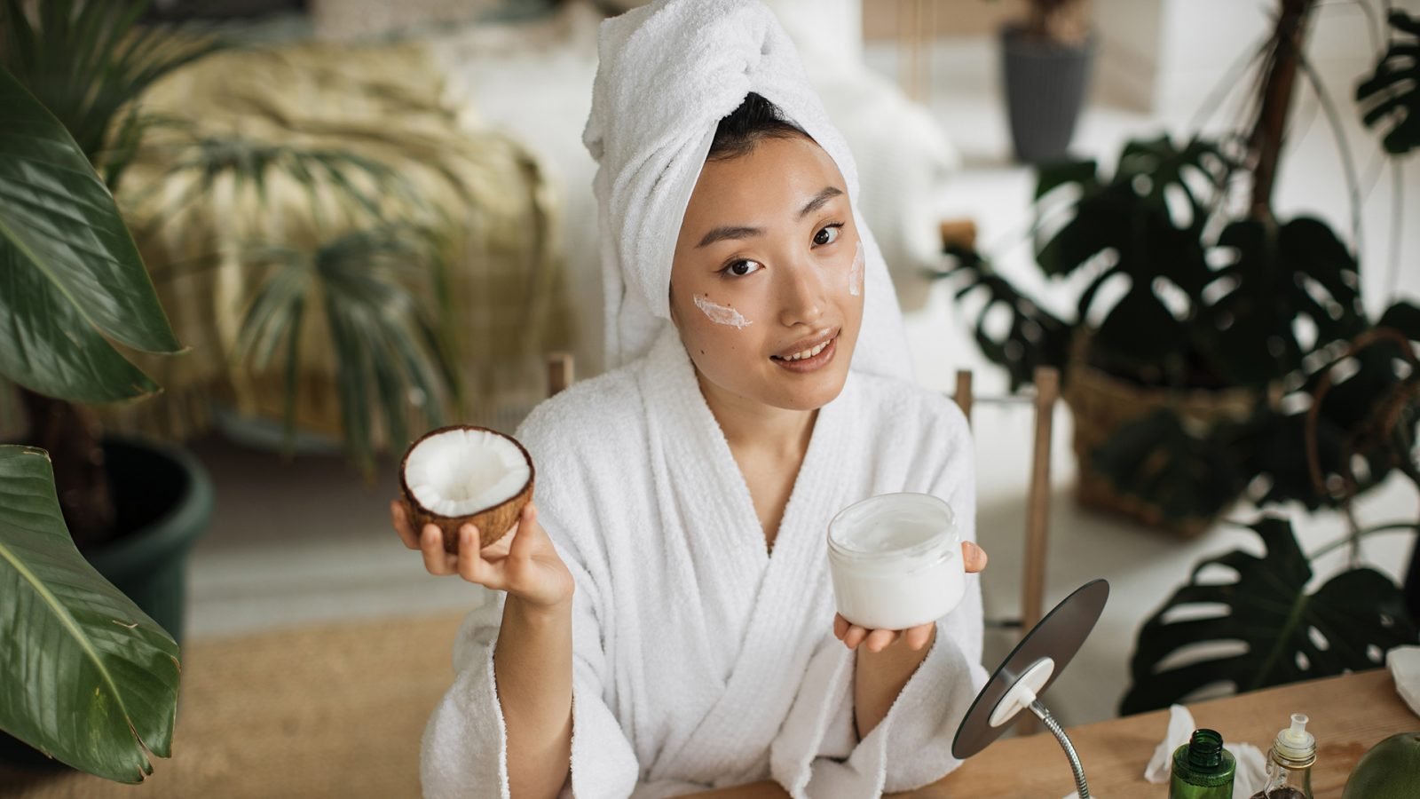 Kobieta trzymająca kosmetyczny olej kokosowy.