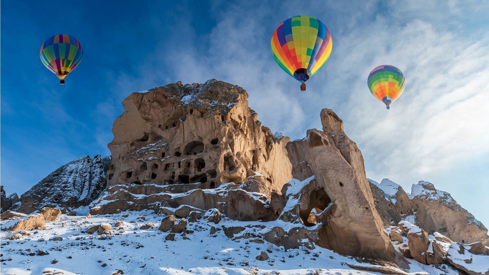 Balony w Kapadocji nad ośnieżoną górą.