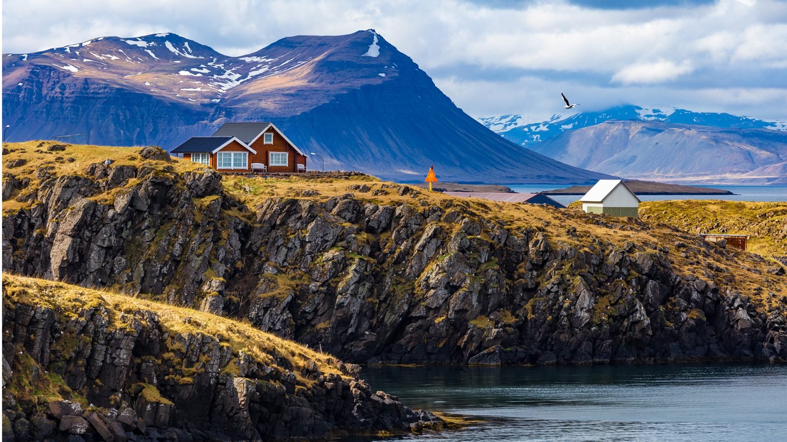 Czerwony domek na tle islandzkich fiordów.