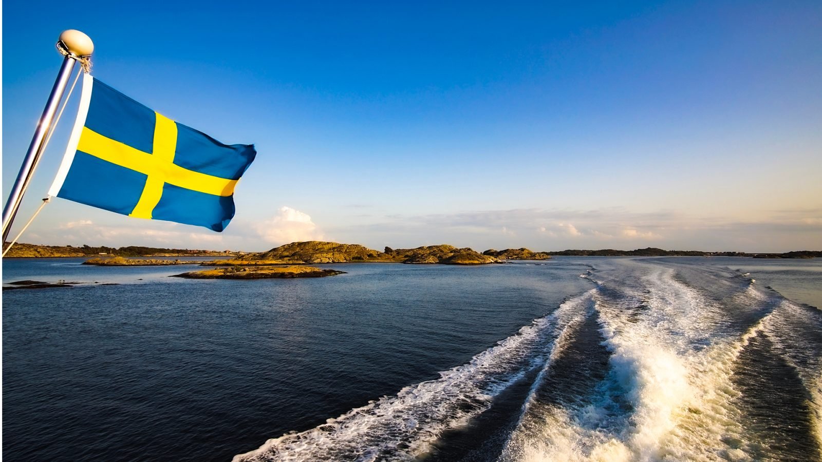 Flaga Szwecji powiewająca podczas rejsu wśród fiordów.