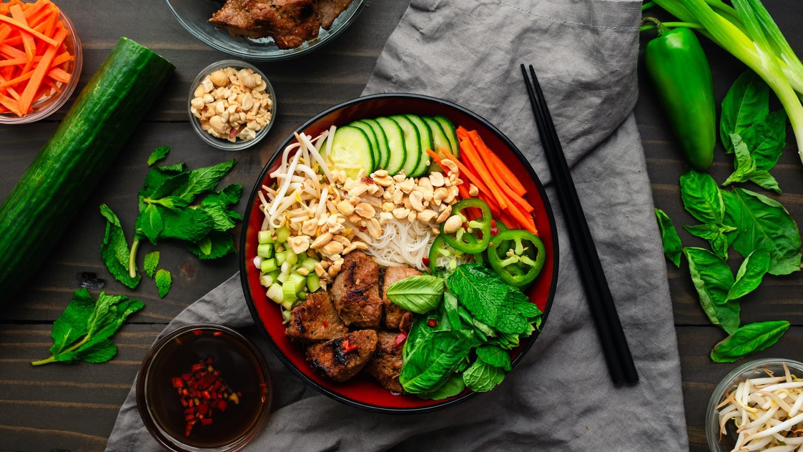 Bun Thit Nuong - kawałki wieprzowiny nad makaronem vermicelli ze świeżymi ziołami, orzeszkami ziemnymi, ogórkiem i marchewką