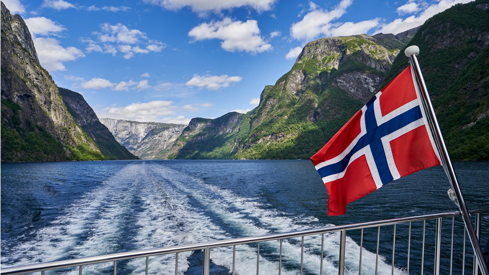 Flaga Norwegii powiewająca podczas rejsu między fiordami.