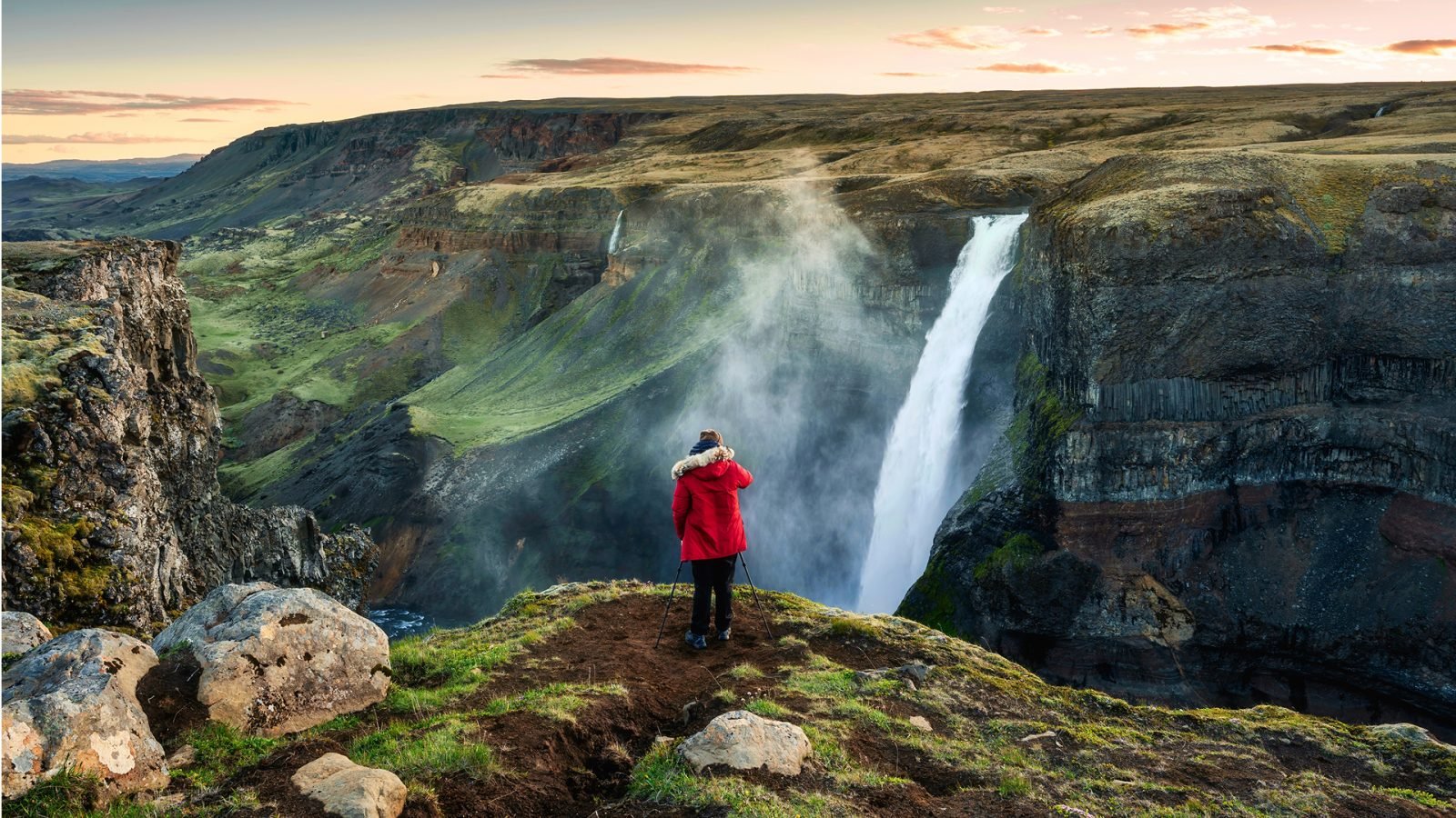 Kobieta obserwująca wodospad, fiordy Islandia.