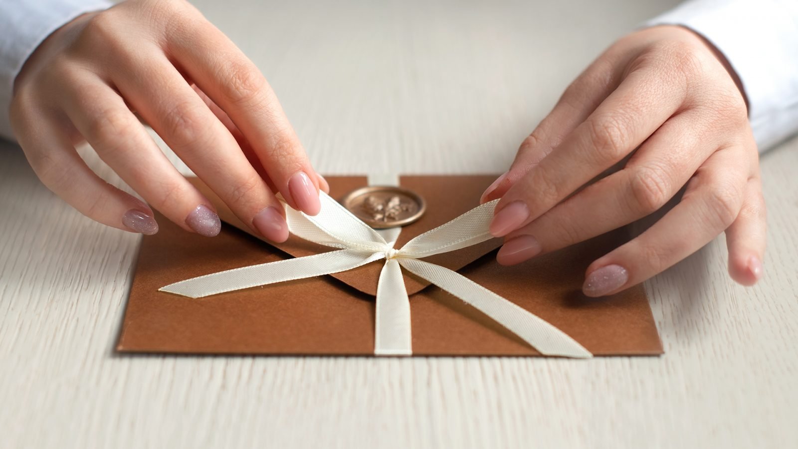 Kobieta zawiązująca kokardkę na kopercie