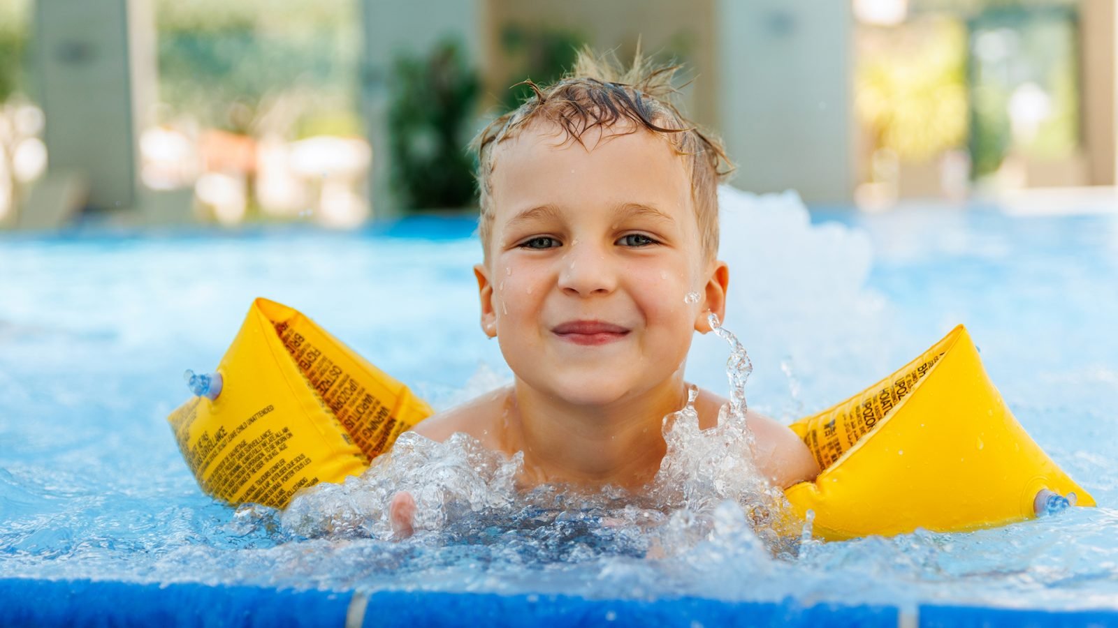 Wesoły chłopiec pływający w basenie