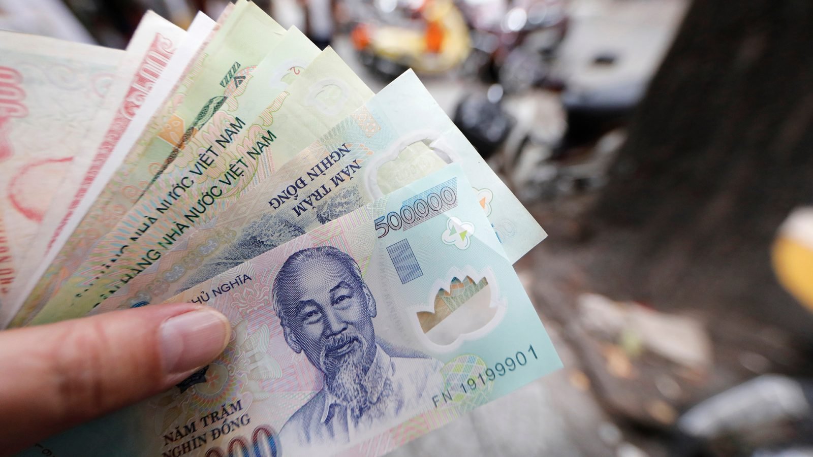 Wietnamskie pieniądze trzymane w dłoni.