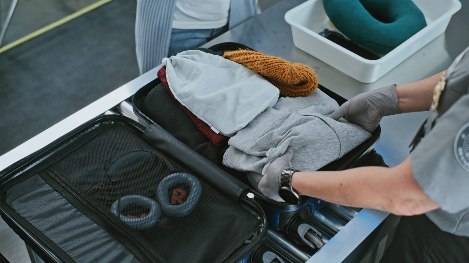 Funkcjonariusz ochrony sprawdza walizkę pasażera