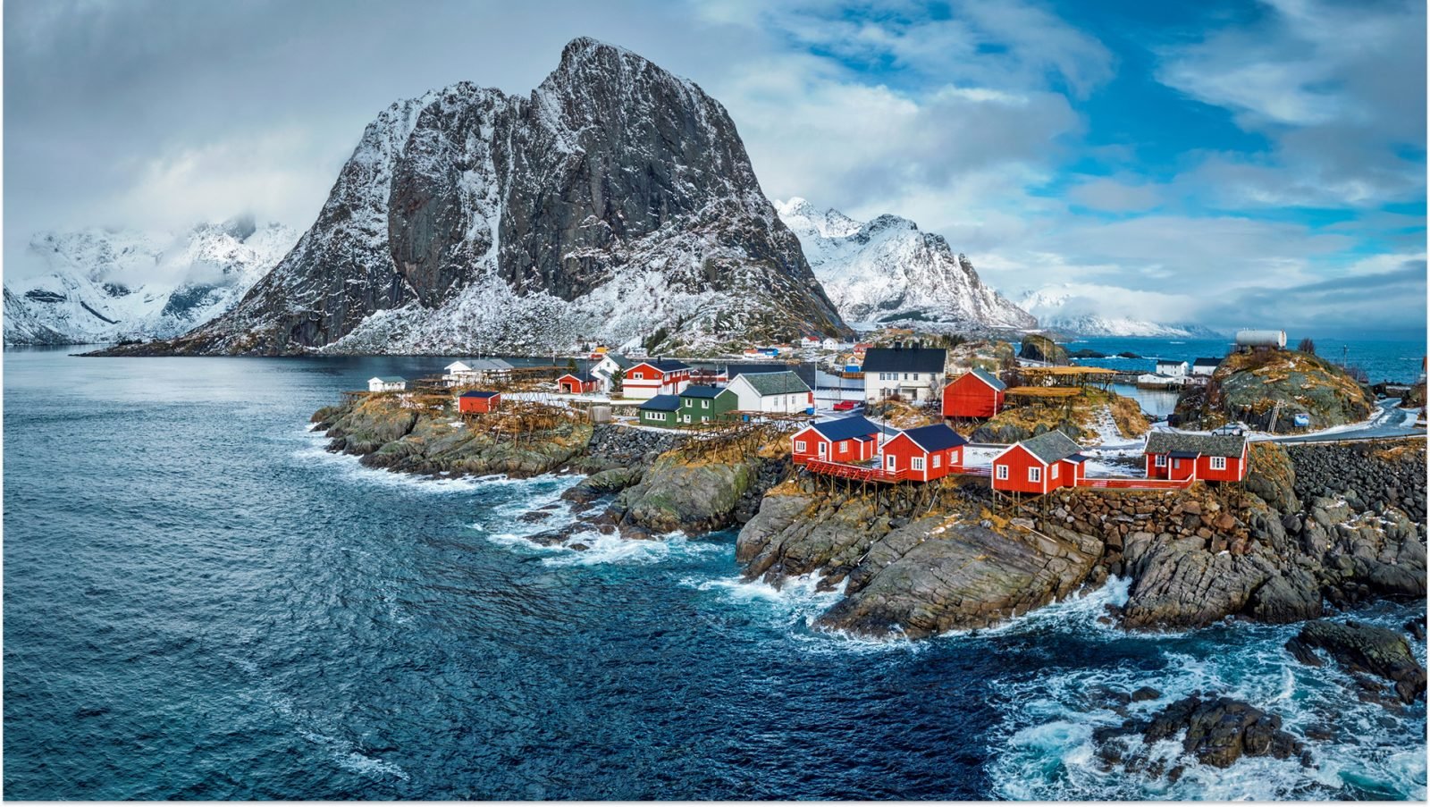 Czerwone norweskie domki w otoczeniu fiordów.