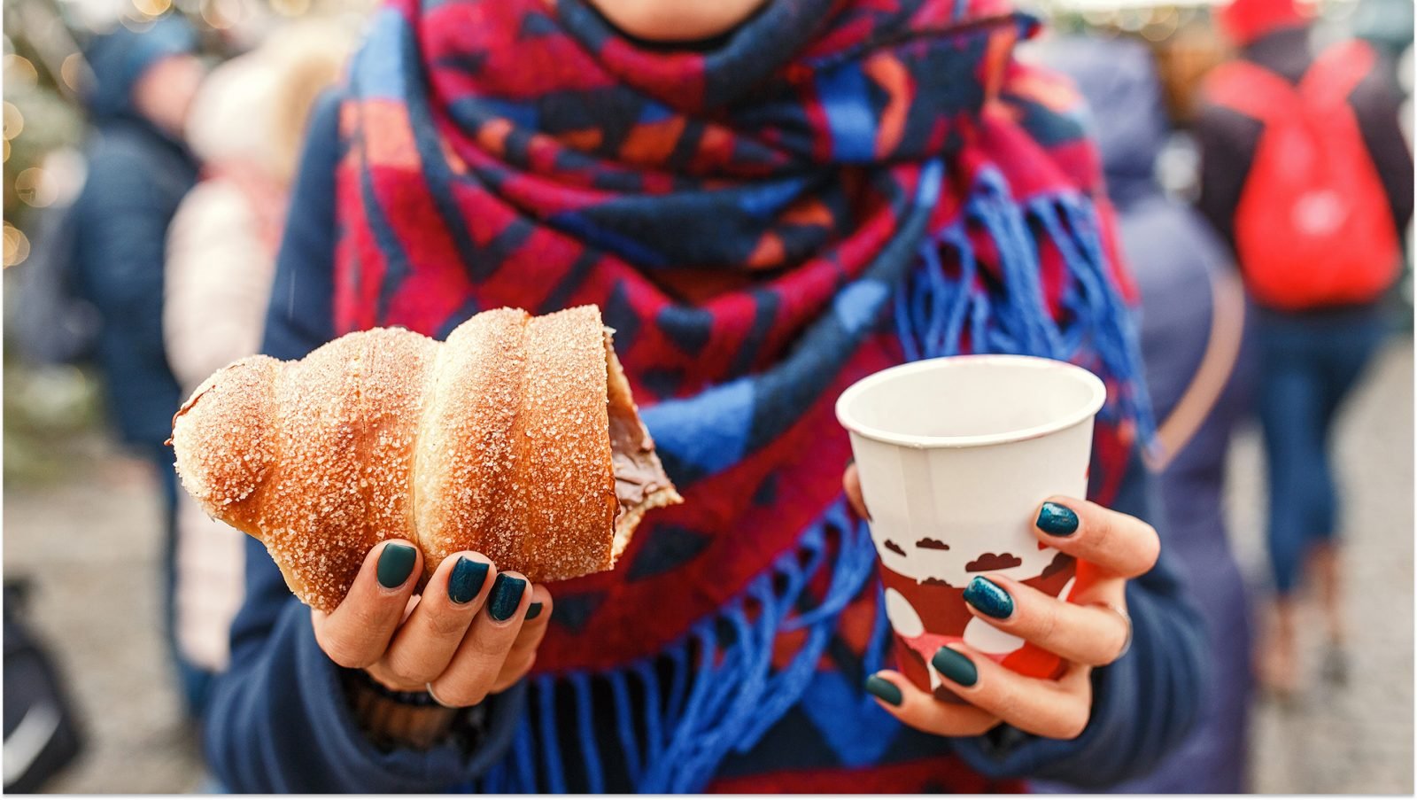 Kobieta trzymająca czeski tradycyjny pyszny trdelnik i gorące wino