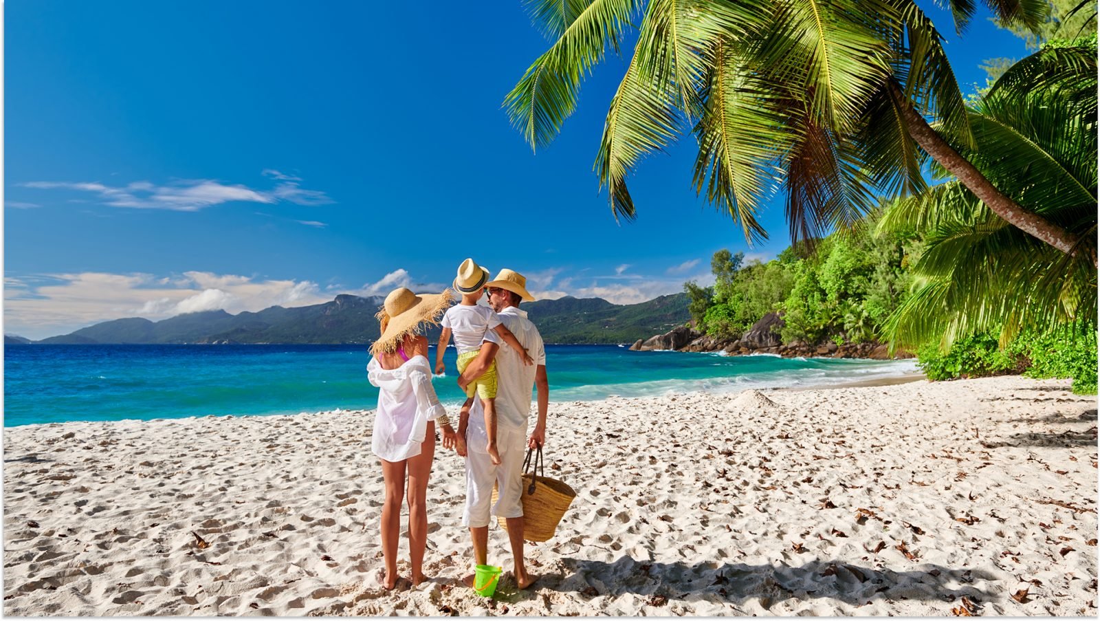 Rodzina na pięknej plaży Anse Soleil, młoda para w bieli z trzyletnim chłopcem. Letnie wakacje na Seszelach, Mahe