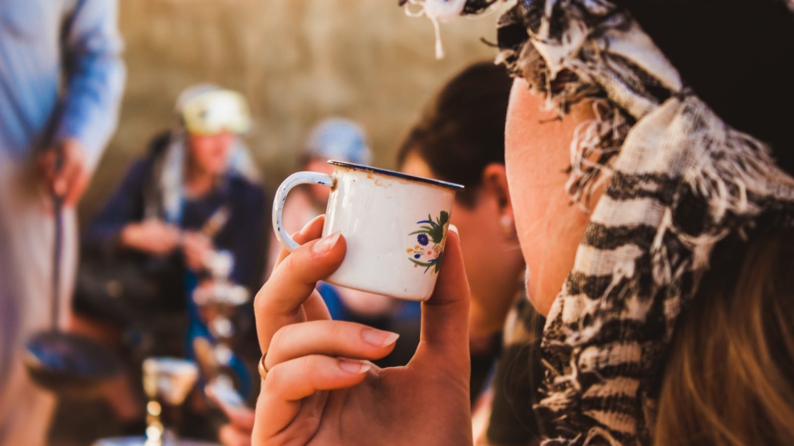 Kobieta w turbanie pijąca czarną herbatę Beduinów na arabskiej pustyni w Egipcie.