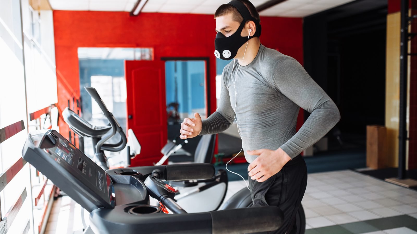 Muskularny młody mężczyzna, uprawiający sport, bieżnia.