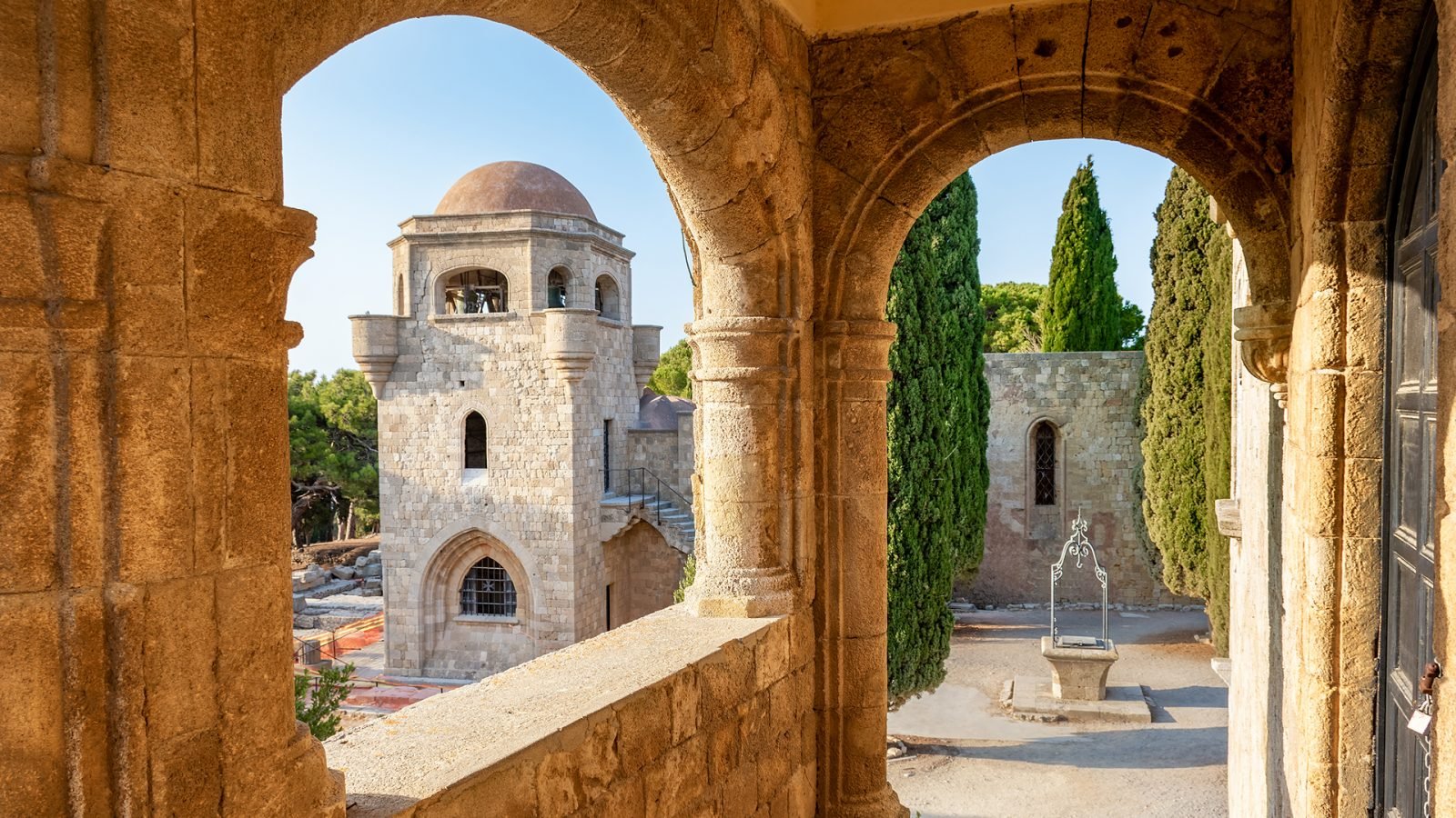 Widok na dzwonnicę klasztoru Filerimos i małą studnię na Akropolu w Jalisos (Rodos, Grecja)