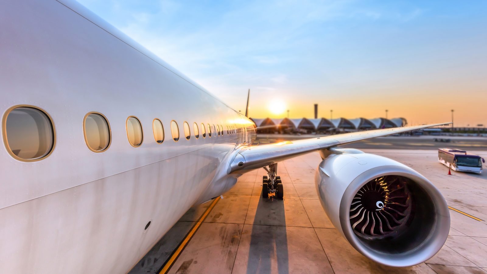 Samolot przygotowywany do startu na międzynarodowym lotnisku o zachodzie słońca.