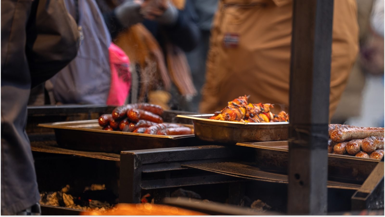Praga, Republika Czeska, Stoisko z kiełbaskami na jarmarku bożonarodzeniowym z grillowanym jedzeniem