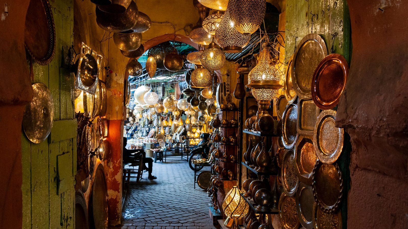 Alejka na sukach w Marrakeszu, z lampami o określonych kształtach.