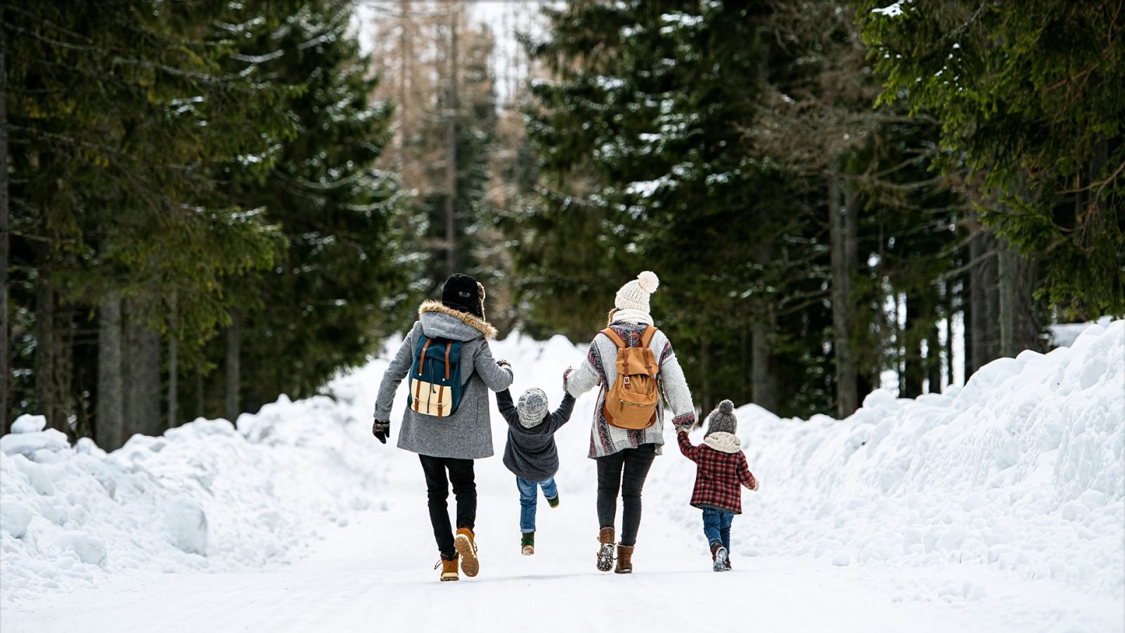 Rodzina spacerująca po zimowym lesie