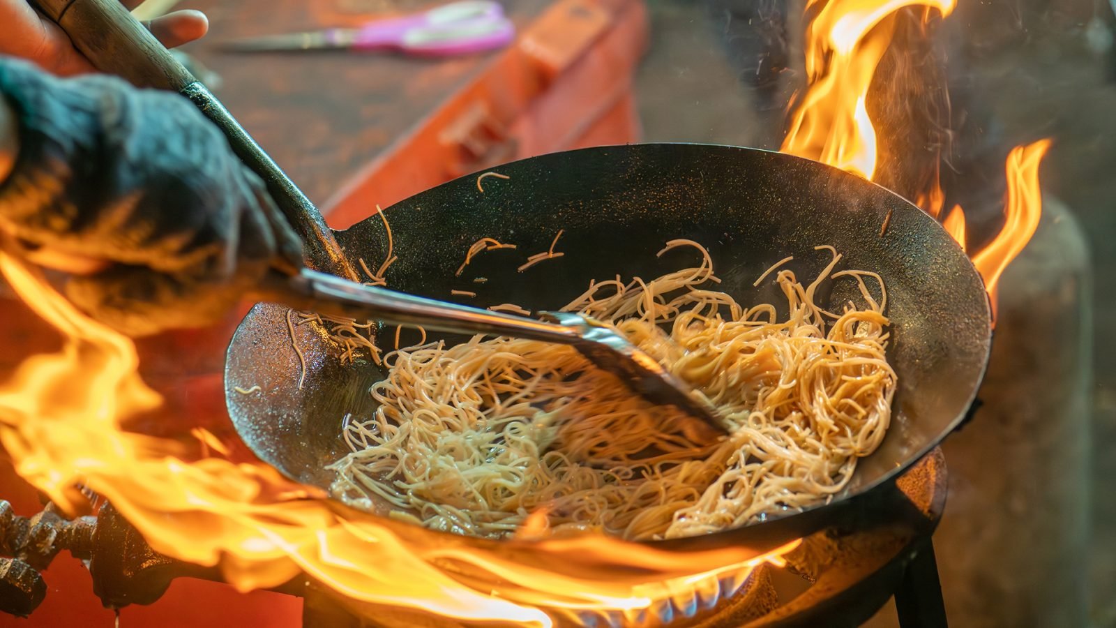 Smażony makaron gotowany na patelni z dużym płomieniem to hongkoński styl. Pad Thai to ulubione i słynne azjatyckie danie uliczne, przygotowywane na gorącej patelni. Pad Thai to smażony makaron ryżowy, tajlandzkie danie uliczne.