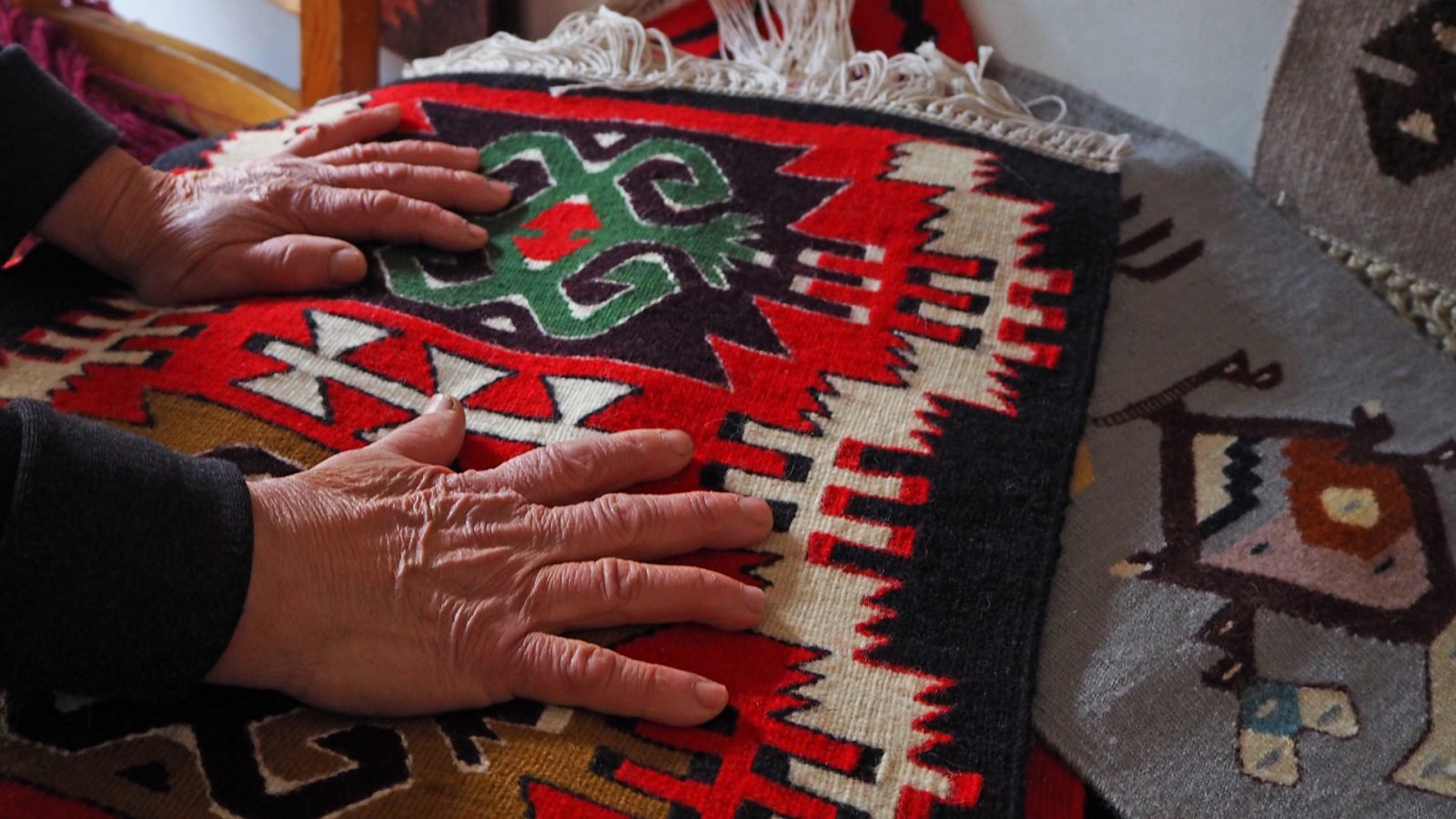 Strasza osoba robiąca kilim.