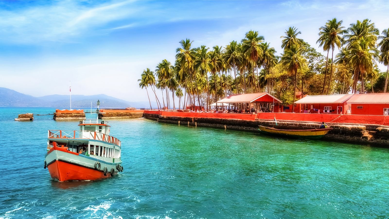 Statek turystyczny w pobliżu plaży na wyspie Ross na Andamanach w Indiach z malowniczym krajobrazem.