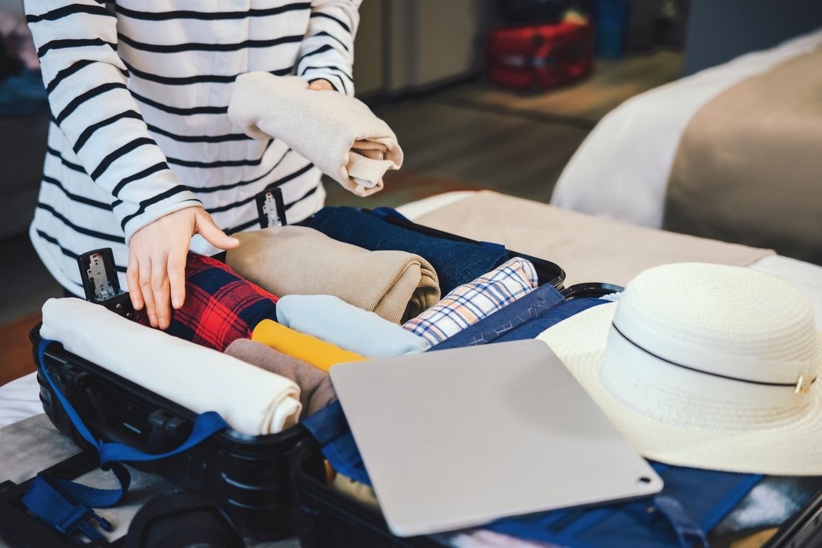 A woman packs a backpack for a cheap city break.